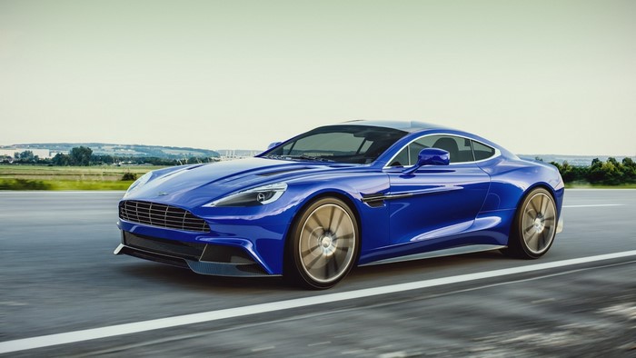Blue Aston Martin Vanquish driving on a road