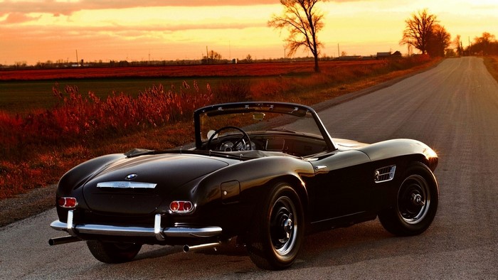 Black BMW 507 Roadster on a country road at sunset