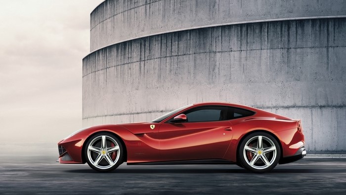 Red Ferrari F12 Berlinetta parked near concrete structure