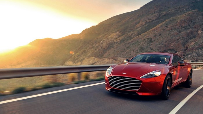 Red Aston Martin Rapide driving on a mountain road