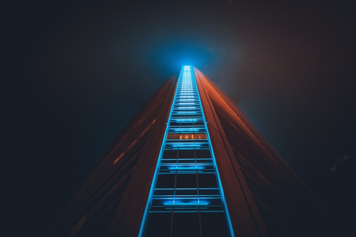Skyscraper with blue and orange lights at night