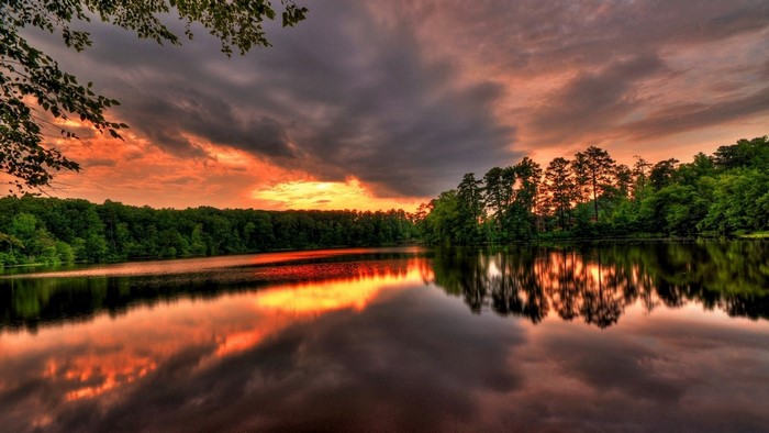 Lake at sunset with forest reflection