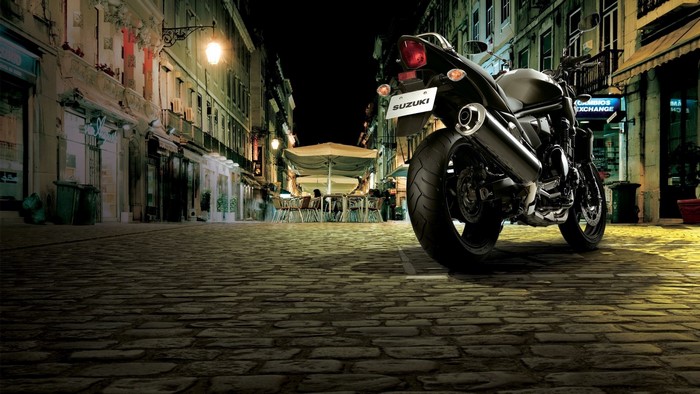 Suzuki Bandit motorcycle parked on cobblestone street at night