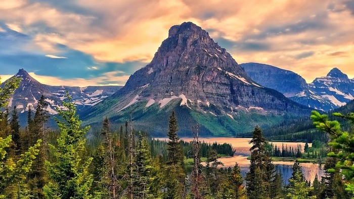 Sunrise over mountains with lake and forest