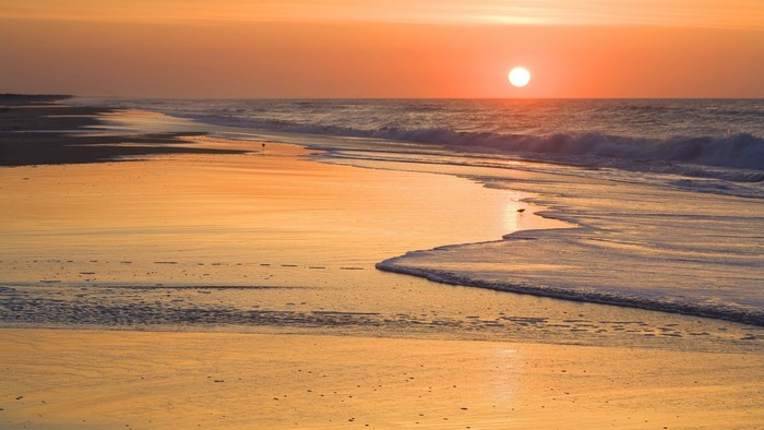 Sunrise over a beach with waves