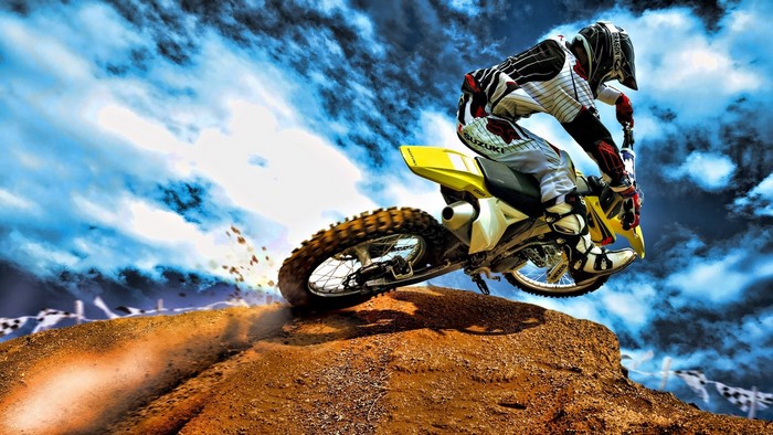 Dirt bike rider jumping over a mound of dirt