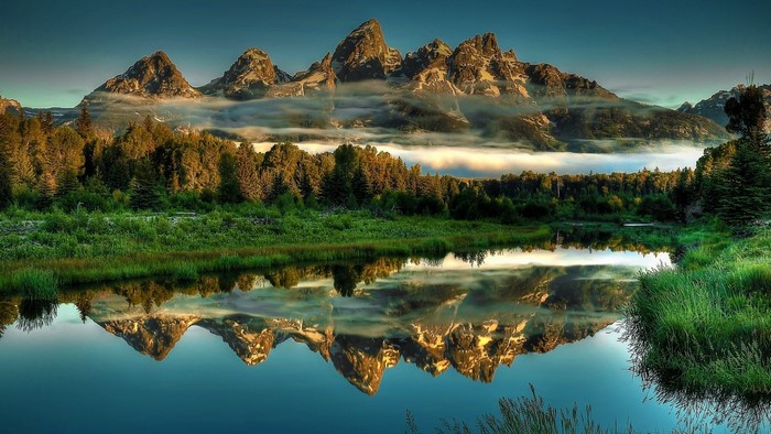 Mountains reflected in a lake with fog