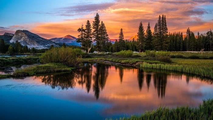 Sunset over a mountain lake with pine trees