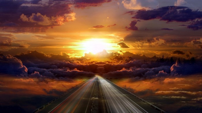 Road through clouds at sunset