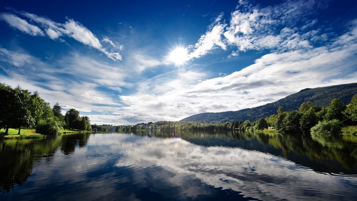 Sunny lake with mountains and trees