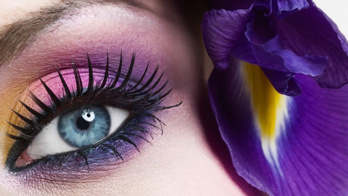 Close-up of a blue eye with vibrant purple and pink eyeshadow