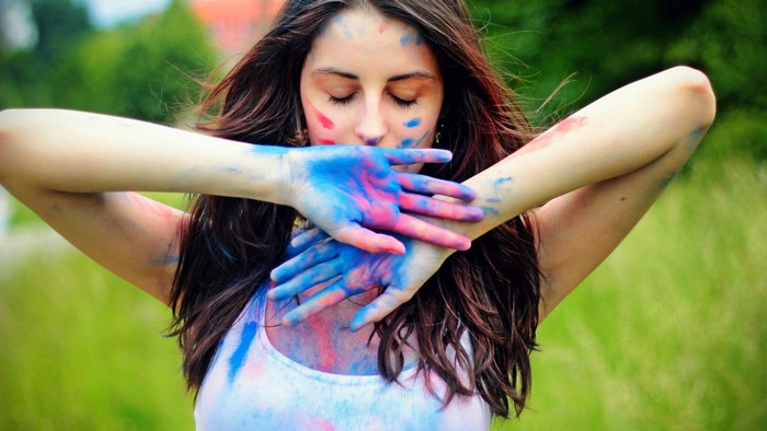 Girl with colorful paint on face and hands