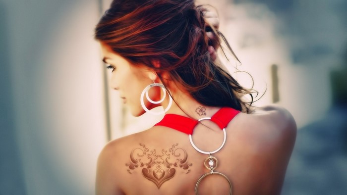Woman with red dress and back tattoo