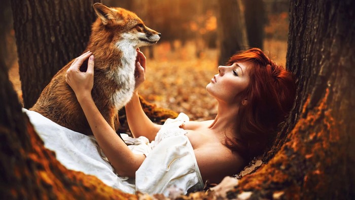 Redhead girl with fox in autumn forest