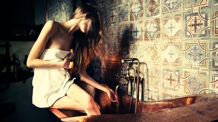 Girl in towel by retro bathtub