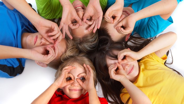 Children making faces with hands over eyes