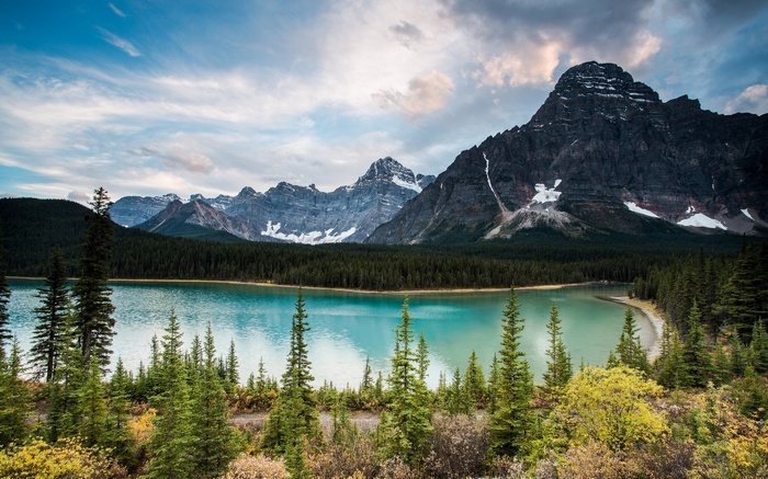 Turquoise lake and mountains with pine forest