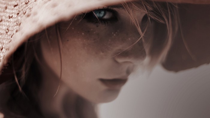Girl with freckles wearing a straw hat