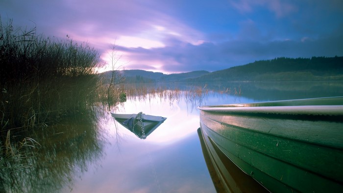 Sinking boat on a lake at sunset