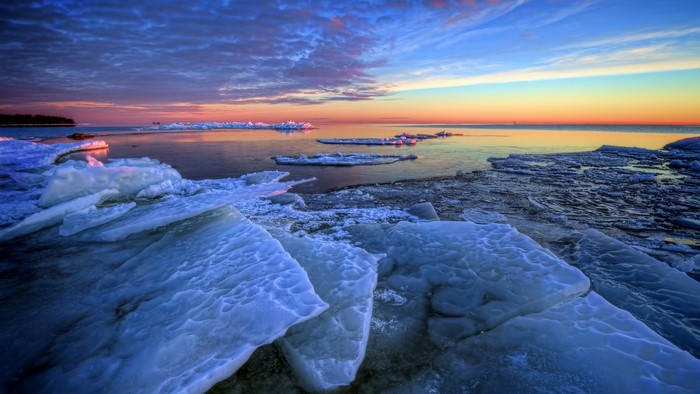 Sunset over a frozen sea with ice floes