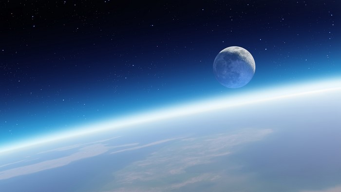 Moon over Earth's atmosphere with stars