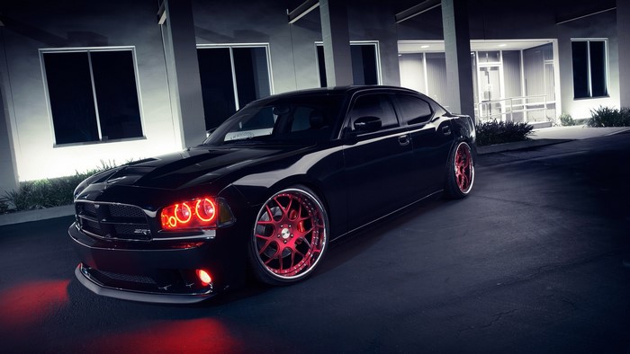 Black Dodge Charger with red lights and rims