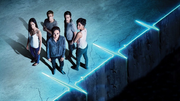 Flatliners cast standing on cracked ground with neon line