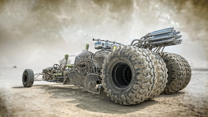 Mad Max fantasy car with large tires and exhaust pipes