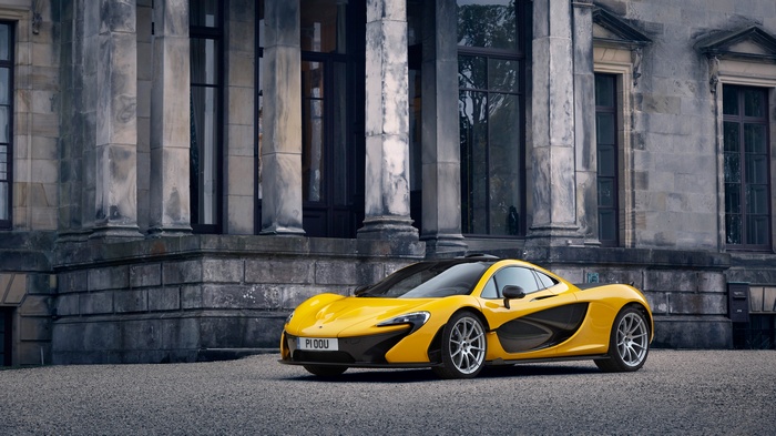 Yellow McLaren P1 in front of a stone building