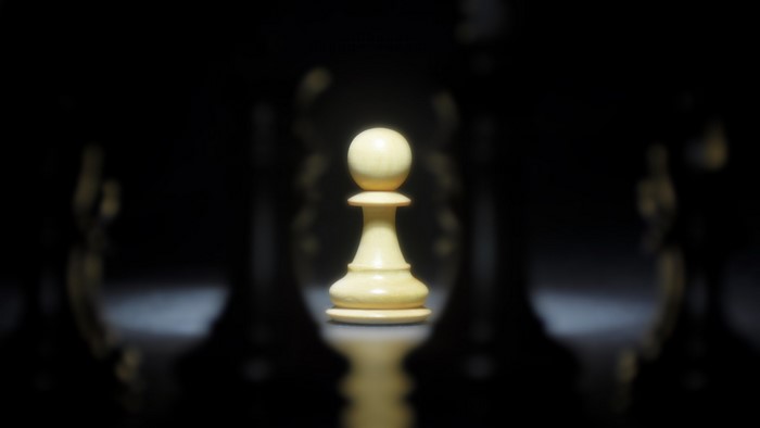 White chess pawn on a dark background