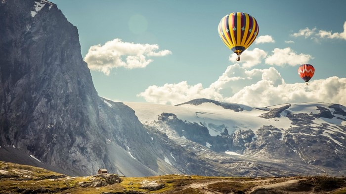 Hot air balloons over snowy mountains