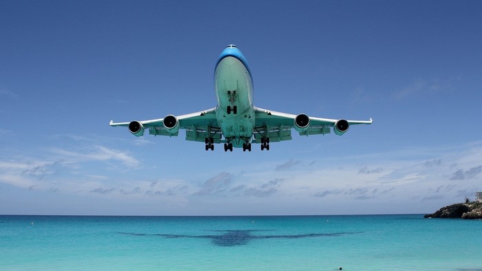 Airplane landing over a tropical ocean