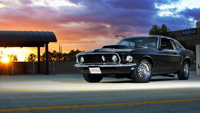 Black 1969 Ford Mustang parked at sunset