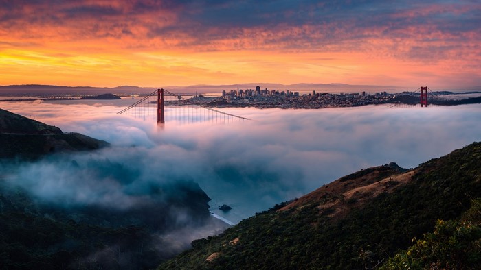 Golden Gate Bridge over fog at sunrise