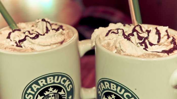 Two Starbucks Frappuccinos with whipped cream and chocolate drizzle