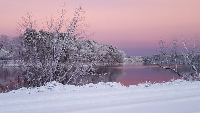 Winter sunrise over a snow-covered landscape and river