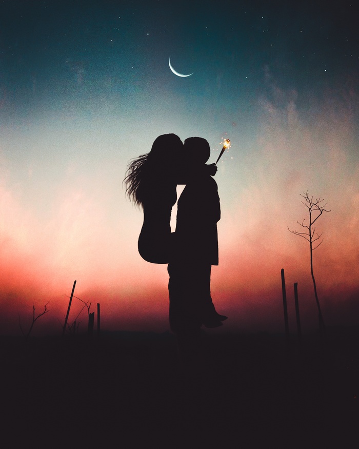 Couple kissing with sparkler at sunset