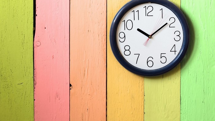 Modern clock on a colorful wooden wall