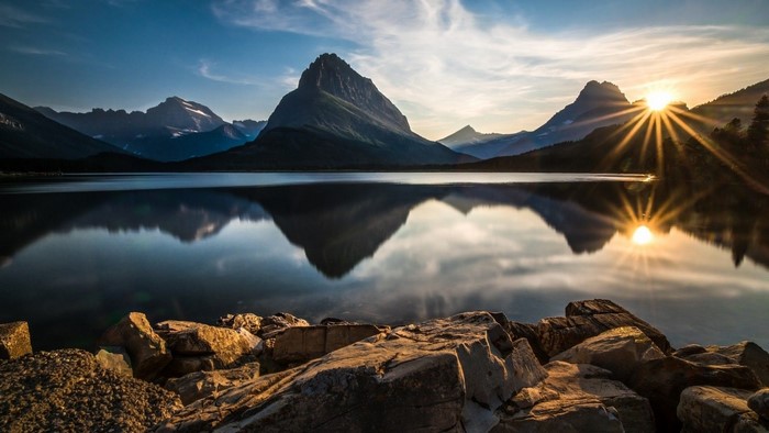 Sunrise over a mountain lake with rocky shore