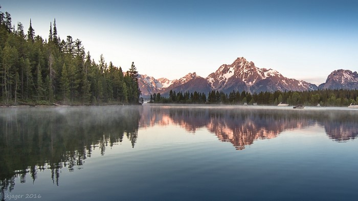 Grand Teton Mountains reflected in a lake at sunrise