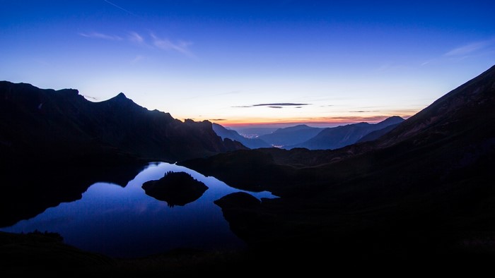 Mountain Lake at Dusk with Distant City Lights