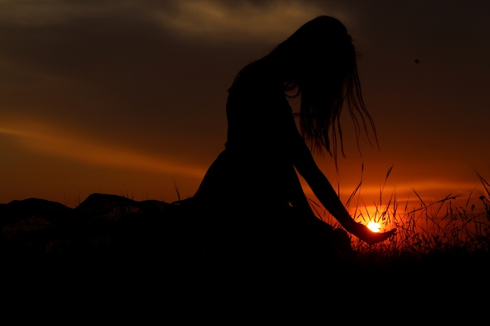 Woman kneeling at sunset