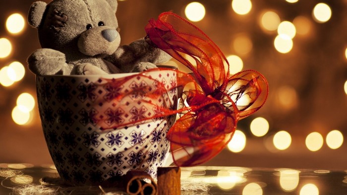 Teddy bear in a mug with ribbon