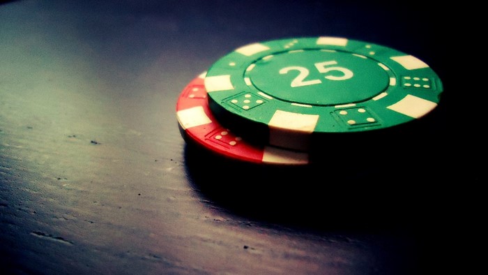 Two poker chips on a dark surface