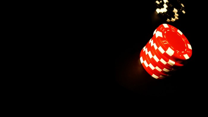 Red and white poker chips on black background