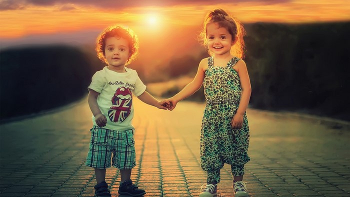 Children holding hands at sunset