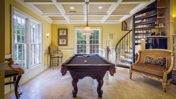 Play room interior with pool table and spiral staircase