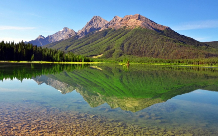 Mountain lake reflection with rocky shore