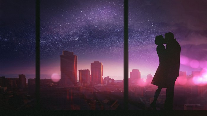 Couple kissing in front of city skyline at night