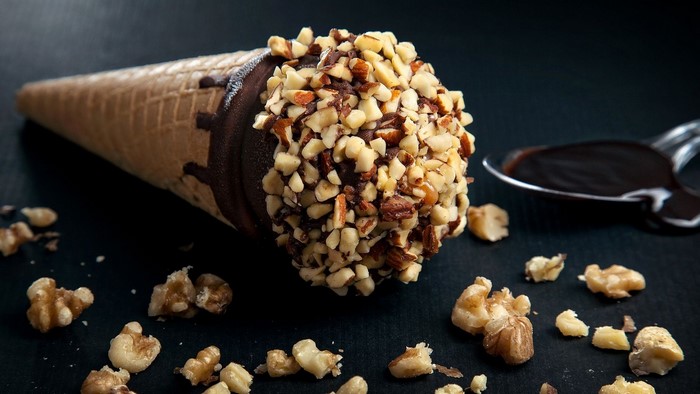 Chocolate ice cream cone with nuts and chocolate sauce
